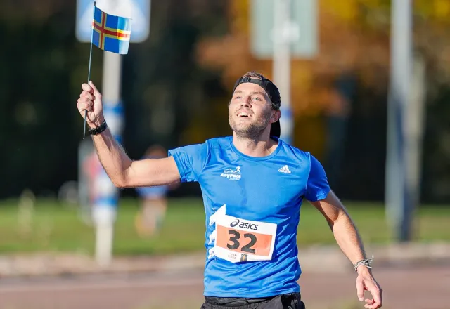 glad vinnare med ålands flagga i handen